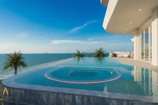 ASONGKHAI Infinity edge swimming pool with a built-in hot tub, overlooking the ocean at sunset.