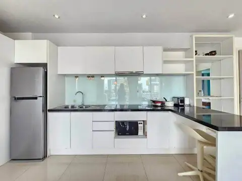 2 Bedroom Condo for Sale at Atlantis Condo Resort white fitted kitchen with stainless steel refrigerator and black countertops