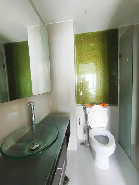 1 Bedroom Condo for Sale at Atlantis Condo Resort bathroom with glass vessel sink and green patterned wall