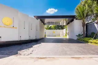 Aura Villa Reserve entrance gate with property name and modern white walls under a clear sky.