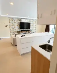 2 Bedroom Condo for Sale at Aurora Pratumnak kitchen counter with sink and view to living room TV area