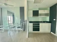 1 Bedroom Condo for Sale at Axis Pattaya Condo open-plan kitchen with black countertop and dining area