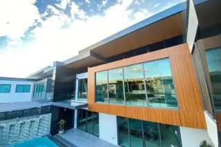 M Mountain Village modern exterior facade with wood cladding large glass windows and poolside view