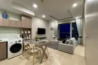 1 Bedroom Condo for Sale at Cetus Beachfront open-plan living area with dining table, washing machine, kitchen cabinets, and balcony