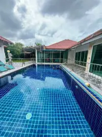 4 Bedroom House for Rent at Baan Balina 3 blue tiled swimming pool with poolside loungers and garden view