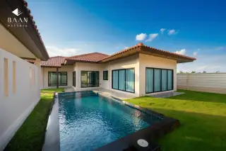 Baan Balina 3: Exterior of a modern house with a small swimming pool and green lawn under a blue sky.