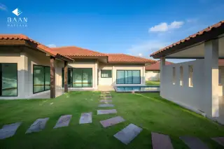 Baan Balina 3: Backyard view of the house with a small pool, green grass, and stepping stones.