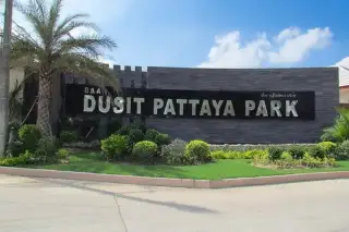 Baan Dusit Pattaya Park aerial view showing numerous houses, a large swimming pool with slides, and green landscape.