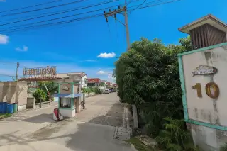 Baan Ngam Charoen 10 entrance gate with security booth, community sign in Thai, and residential street view.