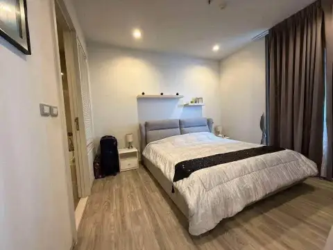 1 Bedroom Condo for Sale at Baan Plai Haad bedroom with gray upholstered bed and wood flooring