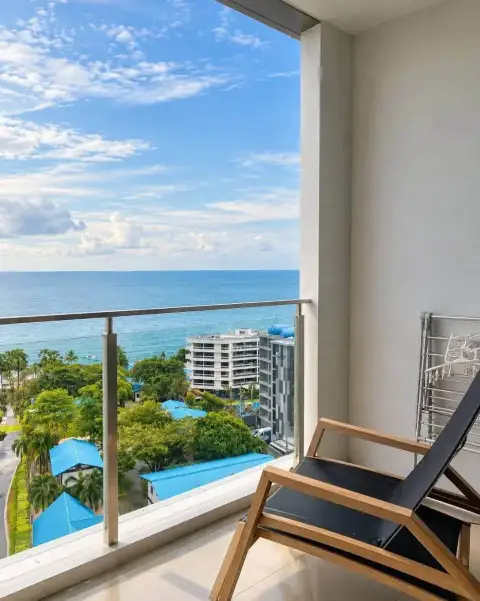 2 Bedroom Condo for Rent at Baan Plai Haad balcony with lounge chair overlooking sea and coastal buildings