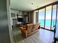 2 Bedroom Condo for Rent at Baan Plai Haad living room with tan leather sofa and floor-to-ceiling sea view windows