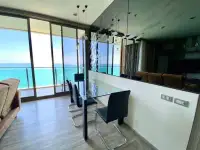 2 Bedroom Condo for Rent at Baan Plai Haad dining table with mirrored fish wall art and panoramic sea view