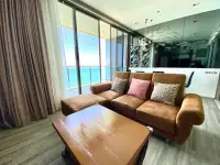 2 Bedroom Condo for Rent at Baan Plai Haad lounge area with brown sofa, coffee table and balcony overlooking the ocean