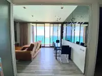 2 Bedroom Condo for Rent at Baan Plai Haad open-plan living and dining area with ocean view through glass balcony doors