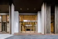 1 Bedroom Condo for Sale at Baan Plai Haad building entrance with modern glass doors and wood-slat canopy
