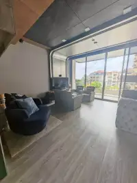 1 Bedroom Condo for Sale at Baan Plai Haad living room with rattan chairs, sofa and balcony city view