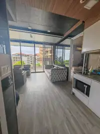 1 Bedroom Condo for Sale at Baan Plai Haad open-plan kitchen and living area with balcony and city skyline view