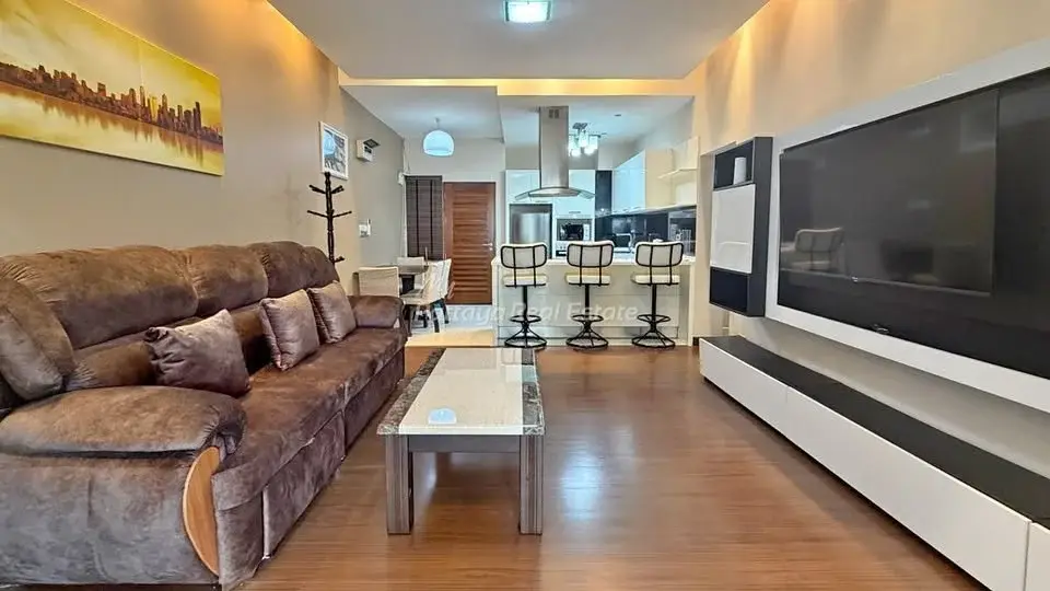 1 Bedroom Condo for Sale at Baan Suan Lalana living room with brown sofa, wood flooring, and breakfast bar