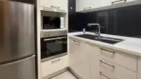 1 Bedroom Condo for Sale at Baan Suan Lalana kitchen with stainless fridge, built-in oven, and microwave