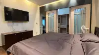1 Bedroom Condo for Sale at Baan Suan Lalana bedroom with wall-mounted TV and mirrored closet doors