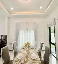 3 Bedroom House for Sale in Bang Lamung elegant dining table set with marble finish and sheer curtains