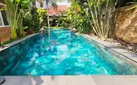 4 Bedroom House for Sale in Bang Lamung long tiled swimming pool surrounded by lush tropical landscaping