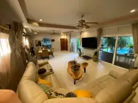 4 Bedroom House for Sale in Bang Lamung open-plan living room with leather sofas, dining area, and pool view