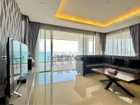 3 Bedroom Condo for Sale at Bang Saray Beach Condominium open-plan living room with leather sofa and ocean-facing balcony