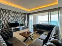 3 Bedroom Condo for Sale at Bang Saray Beach Condominium living area with tufted leather sofas and sea view through glass doors