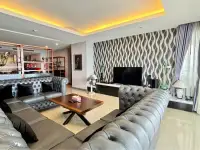 3 Bedroom Condo for Sale at Bang Saray Beach Condominium lounge with patterned accent wall, TV unit, and wooden coffee table