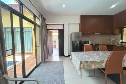 3 Bedroom House for Rent in Bang Sare dining area with kitchen, fridge, and view to pool through glass doors