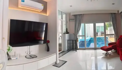 3 Bedroom House for Rent in Bang Sare open-plan lounge with flat-screen TV and sliding doors to pool