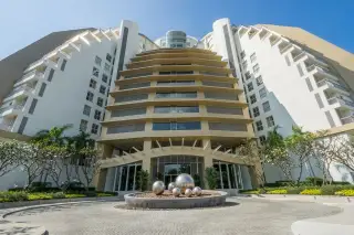 The Cove Pattaya main building exterior with tiered architecture and circular driveway entrance.