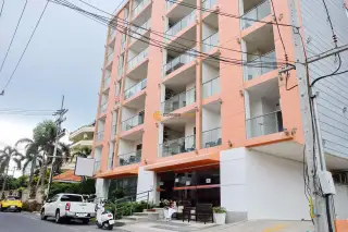 C View Residence 2 living room with brown sofa, Thai wall art, and balcony access in Pattaya condo