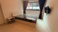 1 Bedroom Condo for Rent at C View Residence Pattaya bedroom with plastic-wrapped bed and window overlooking balcony