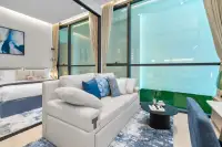 1 Bedroom Condo for Sale at Once Wong Amat: Living room with a white sofa, blue rug, and bedroom visible through a glass wall.