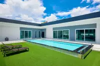 3 Bedroom House for Sale in Nong Prue daytime private pool with green artificial lawn, sunloungers and floor-to-ceiling sliding glass doors