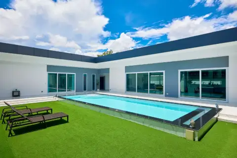 3 Bedroom House for Sale in Nong Prue daytime private pool with green artificial lawn, sunloungers and floor-to-ceiling sliding glass doors