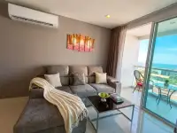 1 Bedroom Condo for Sale at The Vision gray living room sofa with sea view balcony and glass doors
