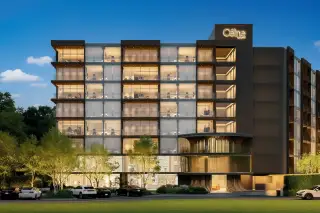 Celine Wongamat modern condo building exterior at dusk with illuminated windows, ground floor entrance, and cars in the parking lot.