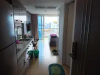 Studio Condo for Sale at Centara Avenue Residence and Suites hallway view of kitchen and living space with balcony