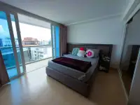 Studio Condo for Sale at Centara Avenue Residence and Suites bed with city skyline view through floor-to-ceiling windows