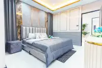 4 Bedroom House for Sale in Central Pattaya bedroom with marble feature wall, grey bedding and decorative lighting