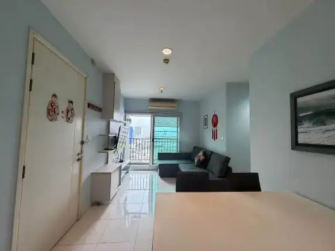 2 Bedroom Condo for Rent at Centric Sea open living area with sofa, balcony door, and city view