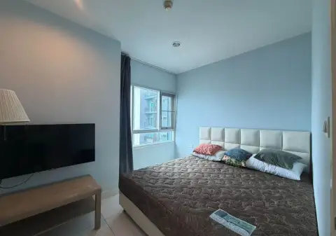 2 Bedroom Condo for Rent at Centric Sea bedroom with king bed, wall-mounted TV, and city view window