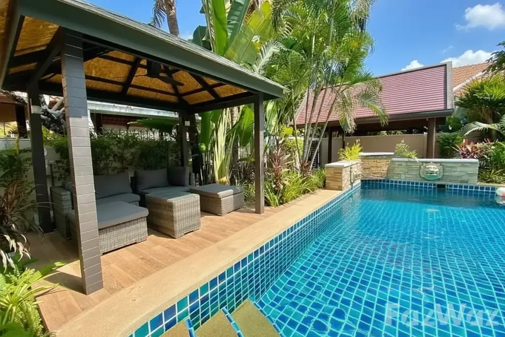 C'est Palai Village outdoor swimming pool with blue tiles, shaded gazebo lounge area, and tropical landscaping.