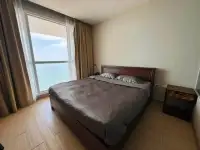 1 Bedroom Condo for Rent at Cetus Beachfront bedroom with wooden bed frame and ocean view window