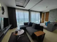 2 Bedroom Condo for Sale at Cetus Beachfront living room with gray sofas and floor-to-ceiling windows