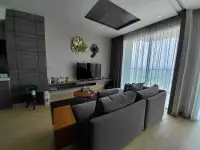 2 Bedroom Condo for Sale at Cetus Beachfront lounge area with TV wall and decorative floral accents